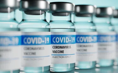 Row of Coronavirus vaccine flasks. Shallow depth of field.