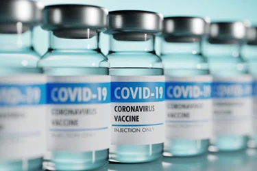 Row of Coronavirus vaccine flasks. Shallow depth of field.